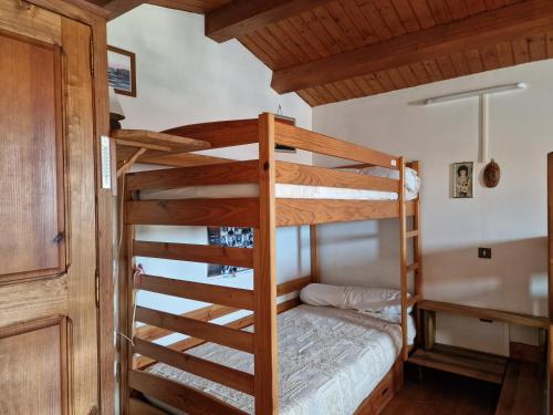 Ce lit superposé se trouve dans un dortoir avec une échelle. dans l'établissement Villa plage et forêt, à La Tranche-sur-Mer