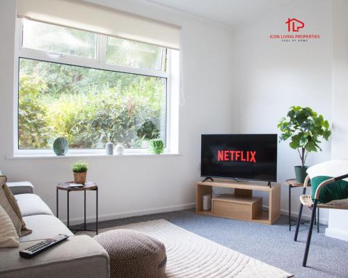 a living room with a tv and a window at Spacious 7-Bed Home for Contractors & Families in St Helens in Saint Helens