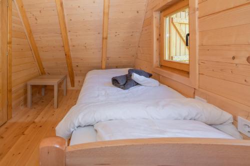 a bed in a wooden room with a window at Etno House Markovic in Kolašin