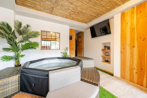 a jacuzzi tub in a room with a tv at Nuit romantique avec spa privatif in Meilhaud