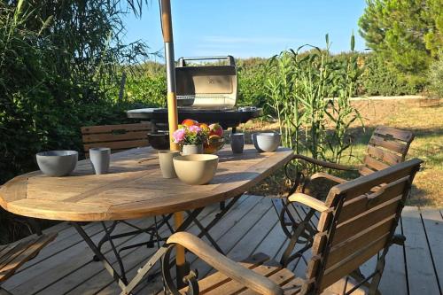 - une table en bois avec un grill et des fleurs dans l'établissement Domaine des Lions - Logement chaleureux climatisé à Sérignan, à Sérignan