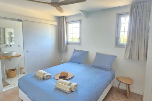 - une chambre dotée d'un lit bleu avec un chapeau dans l'établissement Domaine des Lions - Logement chaleureux climatisé à Sérignan, à Sérignan