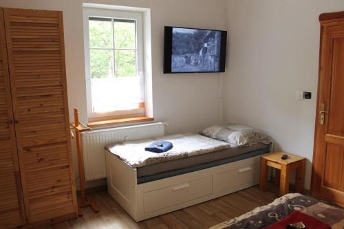 a small bedroom with a bed and a window at Apartmán Petrlenka in Lauterwasser
