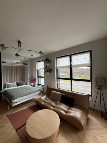 a bedroom with a bed and a couch and a table at WIDOKI3 Apartment Montownia Foodhall in Gdańsk