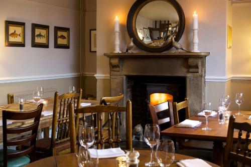a dining room with a table and a fireplace at The Trout at Tadpole Bridge in Faringdon