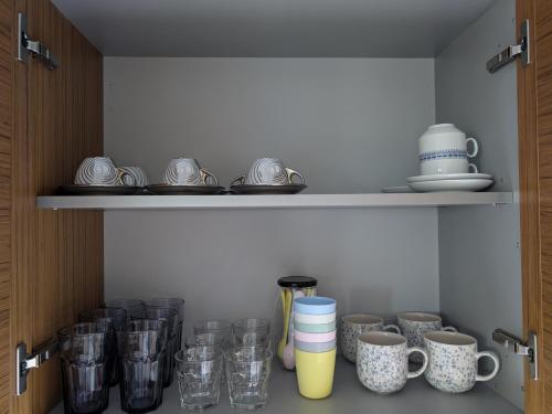 a cupboard filled with lots of glasses and mugs at Luxury Villa in Nature - Akrata Village in Akrata