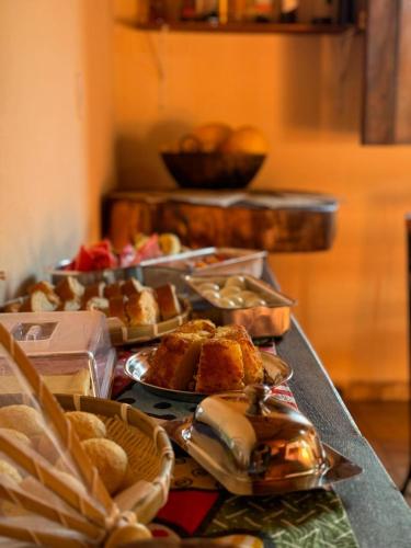 un tavolo sormontato da vassoi di cibo e pasticcini di Pousada Bambuí Terra Ronca a São João