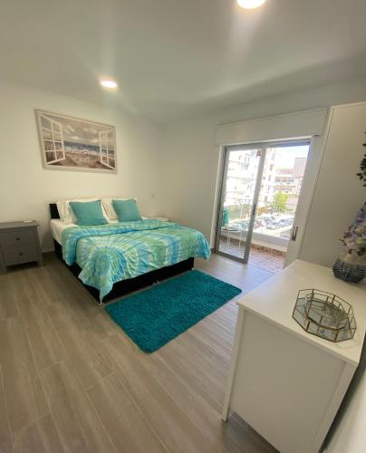 a bedroom with a bed and a door to a balcony at DyLary in Armação de Pêra