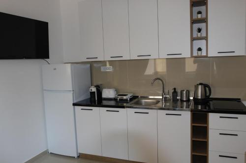 NN Apartment 2 في إسكوبية: مطبخ بخزائن بيضاء ومغسلة