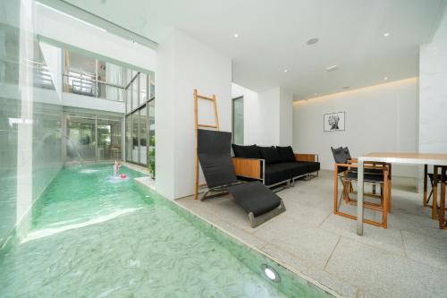 a house with a swimming pool with a table and a dining room at Andaman Villa 15 minutes from Bangtao Beach in Phuket Town