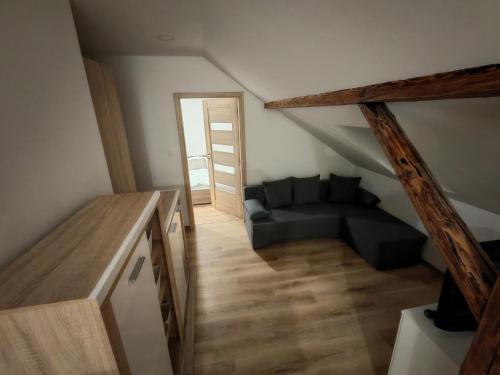 a living room with a couch in the attic at P&T Apartmán in Poprad