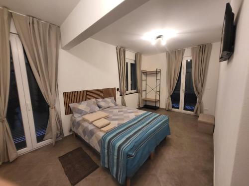 a bedroom with a bed in a room with windows at P r a t o e O n d e in Cogoleto