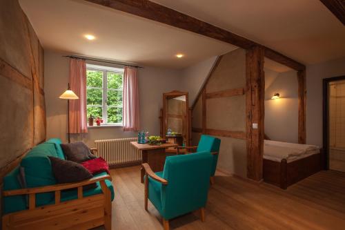 ein Wohnzimmer mit einem grünen Sofa und einem Bett in der Unterkunft Burghotel Stargard in Burg Stargard