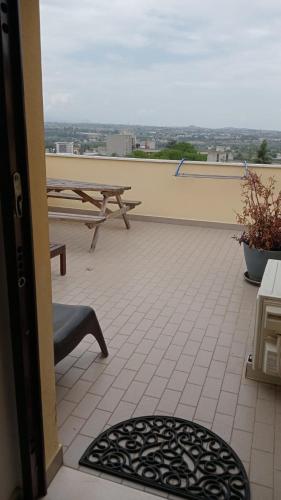 a balcony with a picnic table and a view of the city at La terrazza di Maja in Chieti