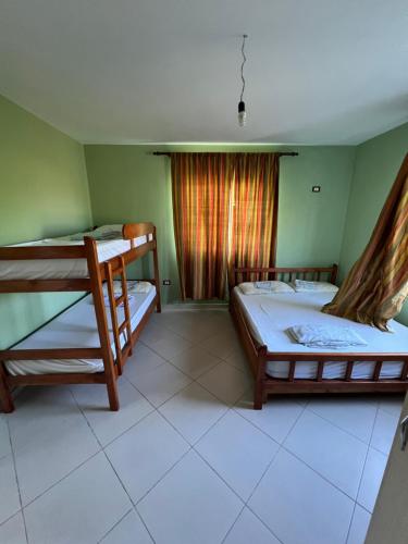 a bedroom with two bunk beds and a window at The White Villa in Hamallë