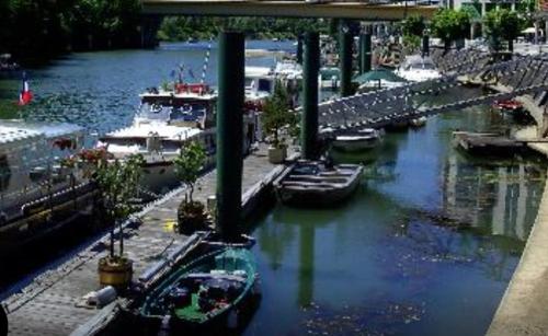 un groupe de bateaux est amarré dans une rivière dans l'établissement Bord de Marne 20mn Paris centre et 20mn Eurodisney, à Nogent-sur-Marne