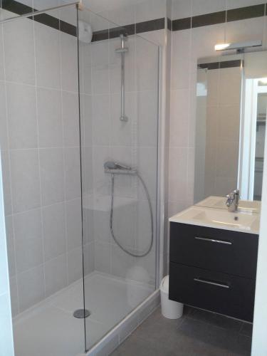 une salle de bain avec douche et lavabo dans l'établissement Sphinx Résidences - Les Germes de Blé, à Épron