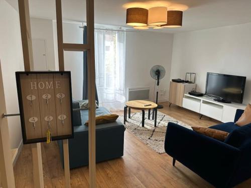 a living room with a couch and a tv at Appartement Douillet Central - Parking Inclus in Manosque