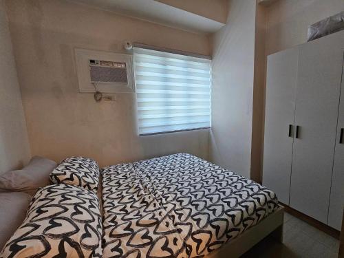 a small bedroom with a bed and a window at Q Workcation WFH Staycation in Manila