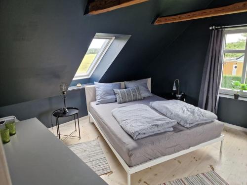 Un dormitorio con una cama y una pared azul. en Close to Hesnæs forest and beach, en Horbelöv