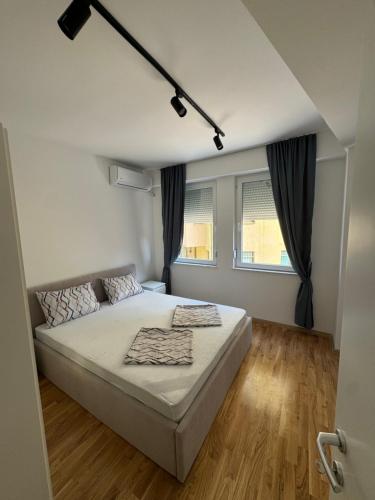 una camera da letto con un letto e due finestre di NN Apartment 3 a Skopje