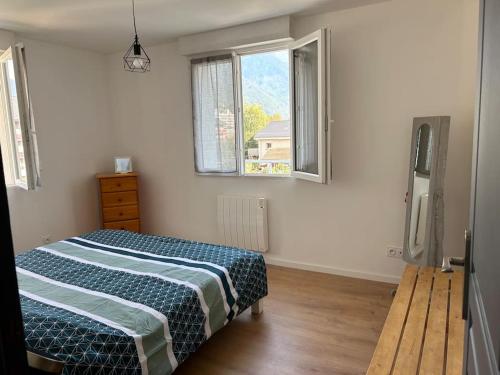une chambre avec un lit et deux fenêtres dans l'établissement Appartement cosy avec 1 place de parking privée, à Albertville
