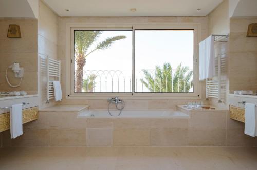 a large bathroom with a tub and a large window at Royal Tulip Korbous Bay Thalasso & Springs in Qurbuş