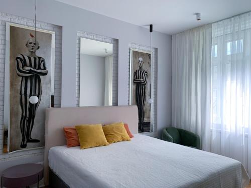 a bedroom with a bed and two statues of men at Pop's Apartments in Belgrade