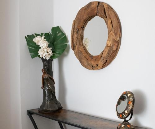a vase of flowers on a table with a mirror at Pop's Apartments in Belgrade