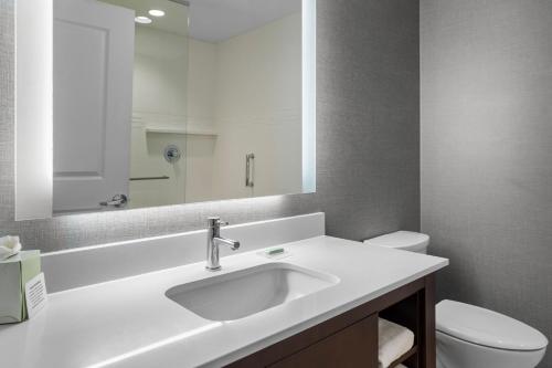 a bathroom with a sink and a toilet and a mirror at Residence Inn by Marriott Cleveland Avon at The Emerald Event Center in Avon