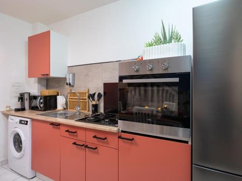 a kitchen with red cabinets and a stove top oven at La Petite Vienna - Vienna authentica in Vienne