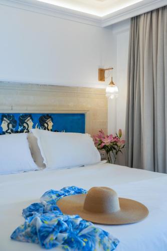 a hat sitting on top of a bed with a bed at Parthenis Beach, Suites by the Sea in Malia