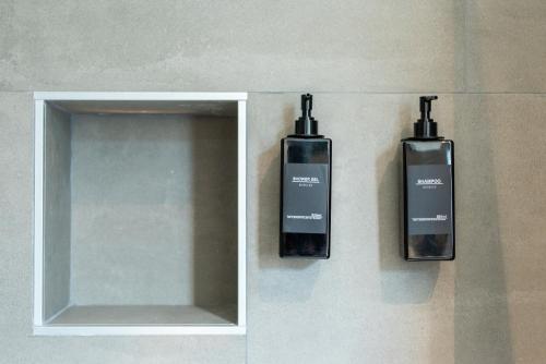 two bottles on the wall next to a mirror at Naviglio suite apartments in Robecco sul Naviglio