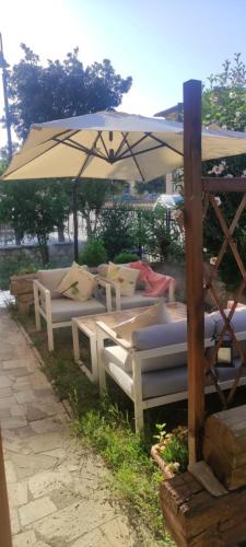 a group of tables and chairs under an umbrella at Casa Giorgiana in Buonconvento