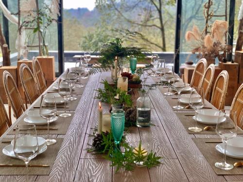 a long table with wine glasses and flowers on it at Hide and see in Sha-p'ing-pa
