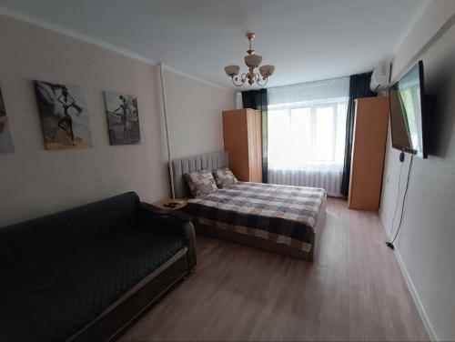 a small living room with a couch and a refrigerator at Уютная 1 комн квартира посуточно в Балхаше Жидебай Батыра, 11 in Balqash