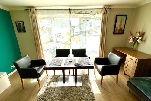 a living room with a table and chairs and a window at Heart of Windsor in Windsor