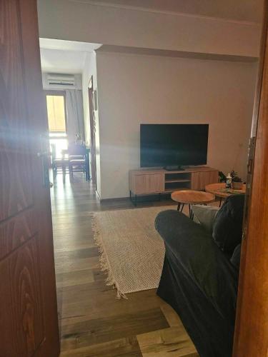 a living room with a couch and a flat screen tv at Spartan Townhouse Apt 4 Spartan Spirit in Sparti