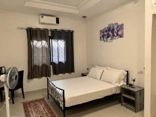 a bedroom with a bed and a window at Maison de vacance Saly in Mbour