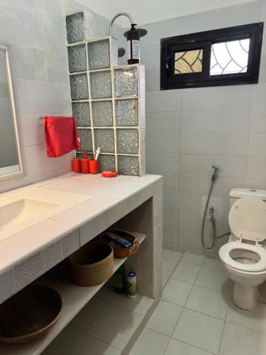 a bathroom with a sink and a toilet at Maison de vacance Saly in Mbour