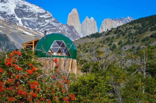 a green building on the side of a mountain at Ecocamp Patagonia in Torres del Paine