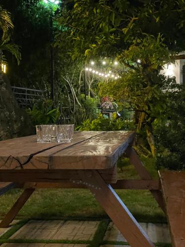 a wooden picnic table with two glasses on it at SATURDAY Homestay Tuy Hòa - Phú Yên in Tuy An