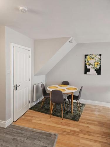 a dining room with a table and chairs and a staircase at Brogans Apartments in Trim