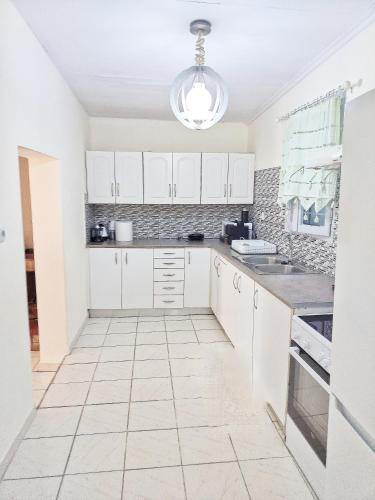 a kitchen with white cabinets and a tiled floor at Beach front house at Agios Ilias Pyrgos Near Ancient Olympia in Áyios Ilías
