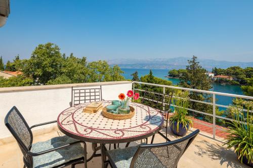a table on a balcony with a view of the water at Holiday Home Dora in Splitska