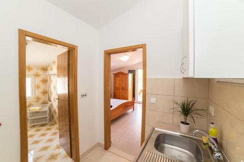 a kitchen with a sink and a room with a bed at Villa Nada in Duće