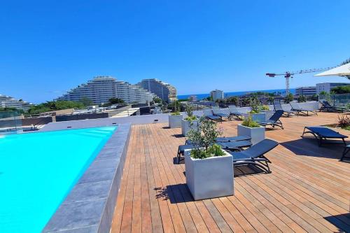- une piscine sur le toit d'un immeuble avec des chaises longues dans l'établissement Bien design avec jacuzzi et piscine, à Villeneuve-Loubet