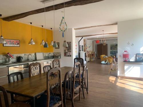 une cuisine et une salle à manger avec une table et des chaises dans l'établissement Grande longère normande, à Doudeville