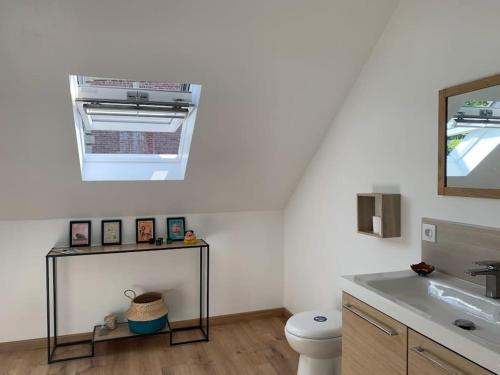 une salle de bain avec un lavabo, des toilettes et un miroir dans l'établissement Grande longère normande, à Doudeville
