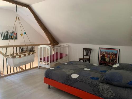 - une chambre avec un lit et un lit bébé dans l'établissement Grande longère normande, à Doudeville